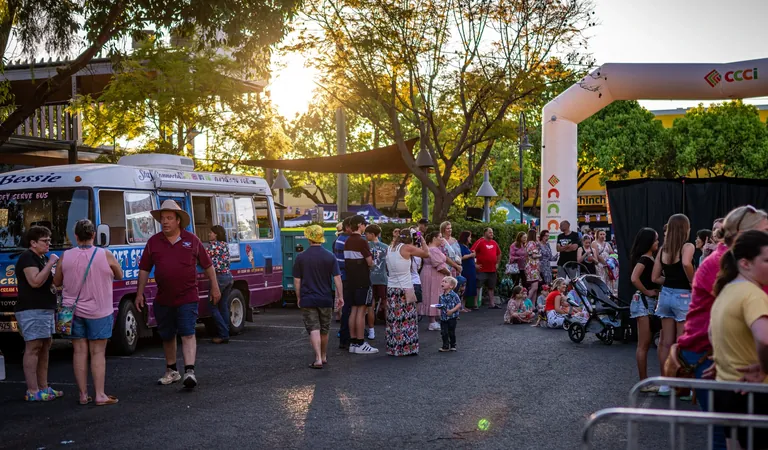 Crowds arriving beside food vendors under the CCCI arch at One Long Table, Chinchilla