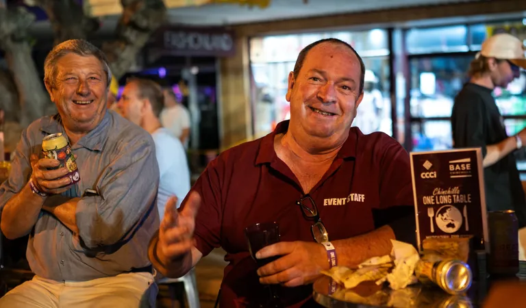 Two guests smiling over food and drinks at One Long Table, Chinchilla