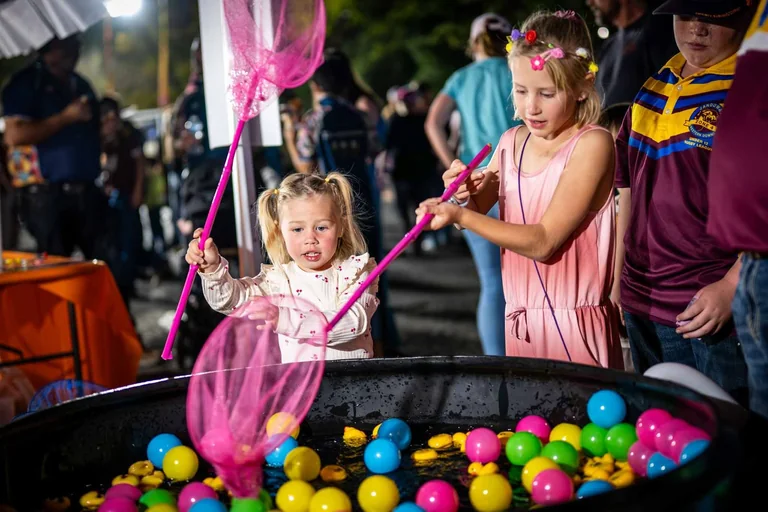 Children playing with nets over a water game in the One Long Table kids area