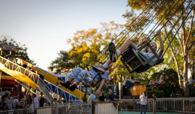 Children riding a spinning swing carnival ride at One Long Table